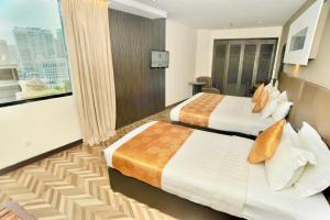 ein Hotelzimmer mit 2 Betten und einem Fenster in der Unterkunft REGALPARK Hotel Kuala Lumpur in Kuala Lumpur