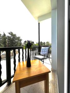 un vase avec des fleurs sur une table en bois sur un balcon dans l'établissement Cosy Sunny One Bedroom Apartment, à Paphos
