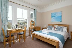 a bedroom with a bed and a desk and a desk at Epchris House in Ilfracombe
