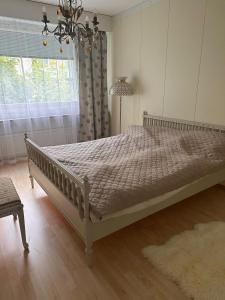 a large bed in a bedroom with a chandelier at Lakeview central residence in Savonlinna