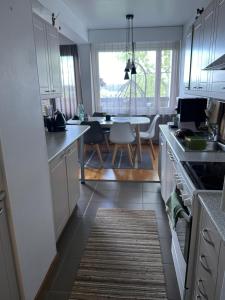 uma cozinha com armários brancos e uma sala de jantar em Lakeview central residence em Savonlinna