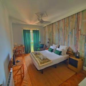 セトゥーバルにあるAlojamentos Vista Mar-Luisa Todiのベッドルーム1室(青いカーテン付きの大型ベッド1台付)
