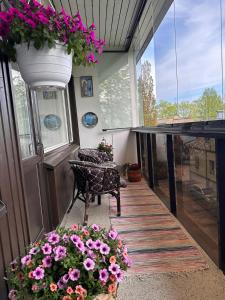 uma varanda com uma mesa e flores num quarto em Lakeview central residence em Savonlinna