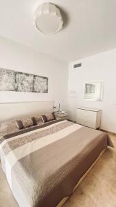 1 dormitorio con 1 cama grande y pared blanca en Arenas Negras PA11, en Puerto de Santiago