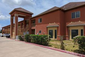 un grand bâtiment rouge avec un parking dans l'établissement Quality Inn, à Brownsville