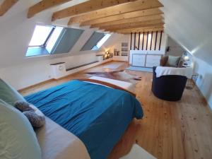 LopérecにあるLe spa du Goaquerのベッドルーム1室(屋根裏部屋に青いベッド1台付)