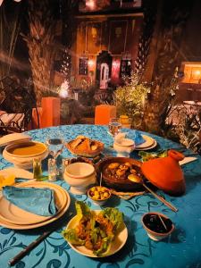 a blue table with plates of food on it at Riad le petit jardin in Zagora