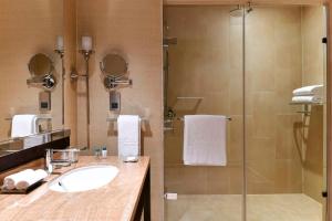 a bathroom with a sink and a shower at Kempinski Hotel Gold Coast City in Accra