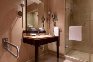 uma casa de banho com um lavatório e um chuveiro em Kempinski Hotel Gold Coast City em Acra