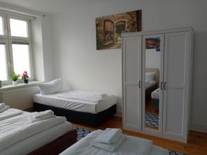 Cette chambre comprend 2 lits et une armoire en verre. dans l'établissement Apartments City Center 8, à Hambourg