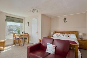 a bedroom with a bed and a couch and a table at Epchris House in Ilfracombe