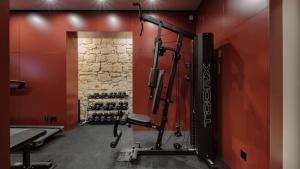 a gym with red walls and a tread machine at Rosselli AX Privilege in Valletta