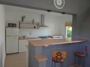 een keuken met een aanrecht met krukken en een koelkast bij casa los sauces in Tandil