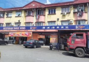 un camion rouge garé devant un bâtiment dans l'établissement Rawang HoBudjet Homestay, à Rawang