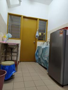 Il comprend une cuisine équipée d'un réfrigérateur en acier inoxydable. dans l'établissement Rawang HoBudjet Homestay, à Rawang