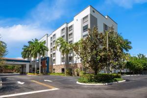 un edificio blanco con palmeras en un aparcamiento en Hampton Inn Weston Fort Lauderdale, en Weston