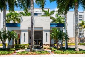 un edificio bianco con palme di fronte di Hampton Inn Weston Fort Lauderdale a Weston