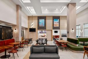 a restaurant with tables and chairs and a couch at Hampton Inn Weston Fort Lauderdale in Weston