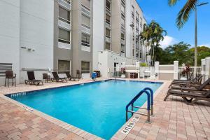 a swimming pool with chairs and a building at Hampton Inn Weston Fort Lauderdale in Weston