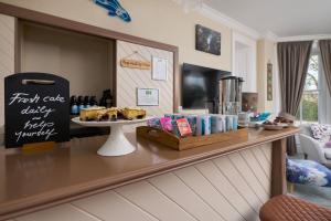 a bakery counter with a plate of food on a table at Epchris House in Ilfracombe