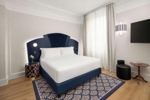 1 dormitorio con 1 cama con cabecero azul en Anglo American Hotel Florence, Curio Collection By Hilton, en Florencia