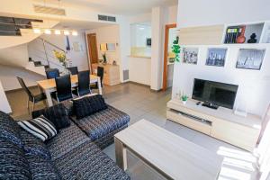 Una sala de estar con un sofá y un comedor. en LITORAL COSTA DORADA - LAS PALMERAS Only families, en Mont-roig