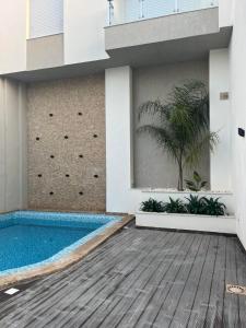 a swimming pool in the middle of a building at Appartement avec piscine et 10 min plage in Hammamet Nord