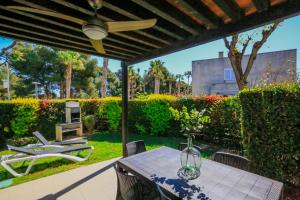 un patio con mesa y sillas bajo un techo en LITORAL COSTA DORADA - LAS PALMERAS Only families, en Mont-roig