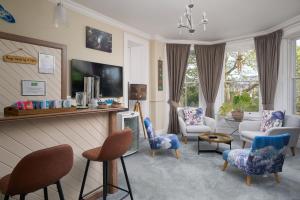 sala de estar con sillas, sofá y TV en Epchris House, en Ilfracombe