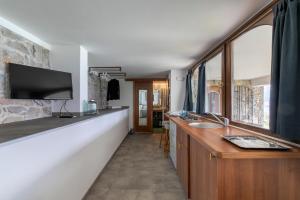 baño con 2 lavabos y TV de pantalla plana en Appartamentino del Sole - Vista Lago, en Brenzone sul Garda