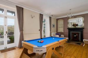 a living room with a pool table and a fireplace at Epchris House in Ilfracombe