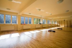 Habitación vacía con suelo y ventanas de madera. en Hotel***NAT Piwniczna Zdrój en Piwniczna