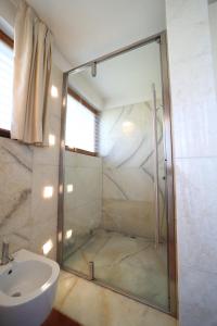 a bathroom with a shower and a toilet and a sink at Villa Vanessa SUITES in Lugano