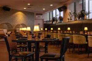 a restaurant with tables and chairs and a bar at Hotel NoMa, Trademark Collection by Wyndham in New Rochelle