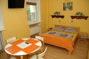 1 dormitorio con 1 cama y 1 mesa con sillas en ORION, en Karpacz