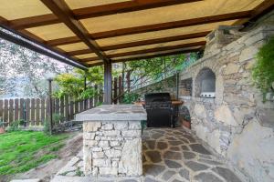 una cocina al aire libre con una pared de piedra en Appartamentino del Sole - Vista Lago, en Brenzone sul Garda