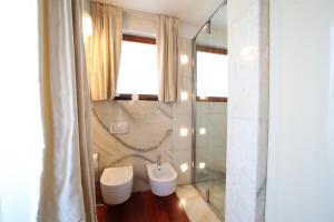 e bagno con servizi igienici, lavandino e doccia. di Villa Vanessa SUITES a Lugano