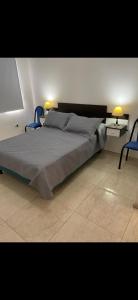 a bedroom with a bed with two chairs and two lamps at Acordes de Gaitas dpto1 in Malargüe