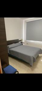 a bedroom with a large bed and a chair at Acordes de Gaitas dpto1 in Malargüe +3 photos
