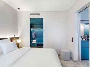 a bedroom with a white bed and a blue closet at Novotel Hamburg Central Station in Hamburg