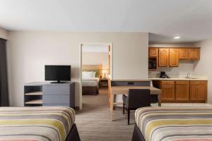 a hotel room with two beds and a kitchen at Country Inn & Suites by Radisson, Jackson-Airport, MS in Pearl