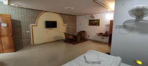 sala de estar con sofá y pared de ladrillo en The Cozy One (tikuri), en Khajurāho