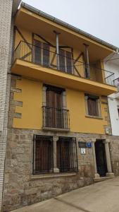 un edificio amarillo con balcón en la parte superior en Casa Rural Maire, en Gata