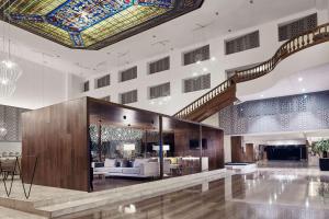 a lobby with a staircase and a living room at Wyndham Monterrey Ambassador Centro in Monterrey