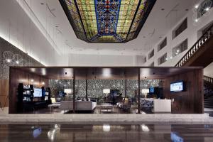 um átrio com um grande tecto de vitrais e uma sala com sofás em Wyndham Monterrey Ambassador Centro em Monterrey