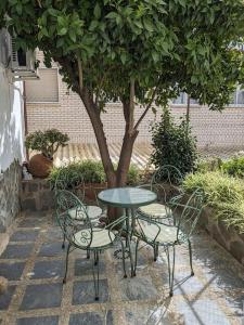 a table and chairs with a table and a tree at Casa Rural Maire in Gata