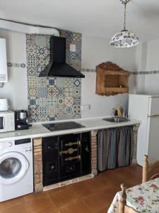 a kitchen with a stove and a washing machine at Casa Rural Maire in Gata