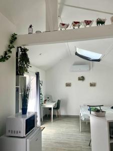 sala de estar con microondas y mesa en Casa 4 Saisons - Studio - Piscine et Jardin - Brive, en Brive-la-Gaillarde