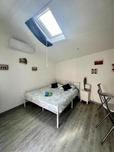 1 dormitorio con 1 cama en una habitación con tragaluz en Casa 4 Saisons - Studio - Piscine et Jardin - Brive, en Brive-la-Gaillarde