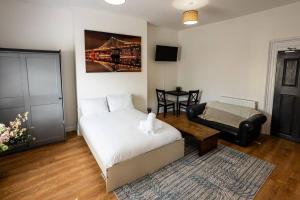 een slaapkamer met een bed, een bank en een tafel bij Studio Coastal Escape Apartment 2 in Christchurch